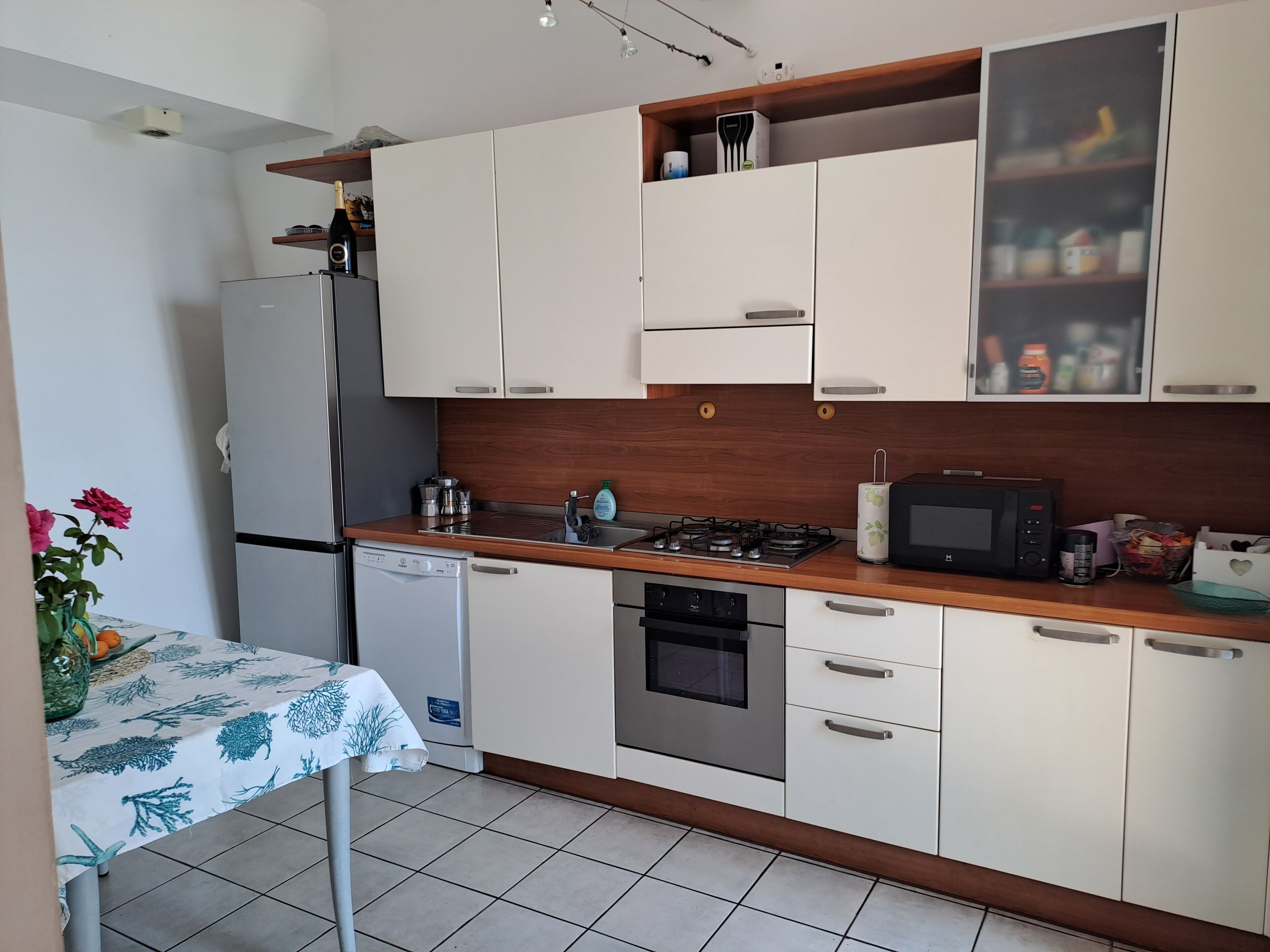 A modern kitchen with white cabinets, a built-in microwave, a gas stove, and a dishwasher.