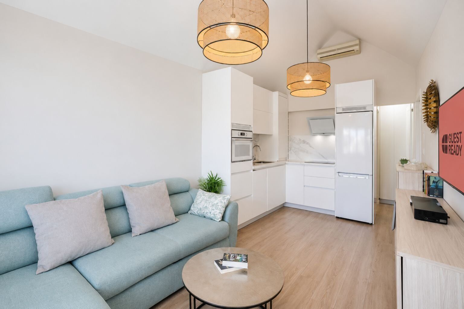 Um apartamento moderno com sofá, mesa de centro, cozinha e sala de estar.