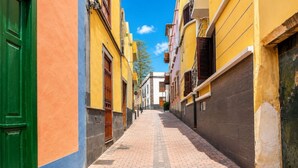 Eine enge Straße, gesäumt von Gebäuden in verschiedenen Architekturstilen und Farben.