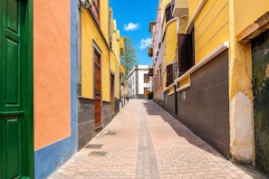 Eine enge Straße, gesäumt von Gebäuden in verschiedenen Architekturstilen und Farben.