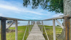Un muelle de madera que se extiende hacia una masa de agua, con un barco amarrado cerca.