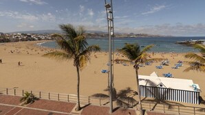 A beach with palm trees, a clear sky, and a view of the sea. - GuestReady - 01C Livian Suites Ext 4 Pax (Las Palmas de Gran Canaria)
