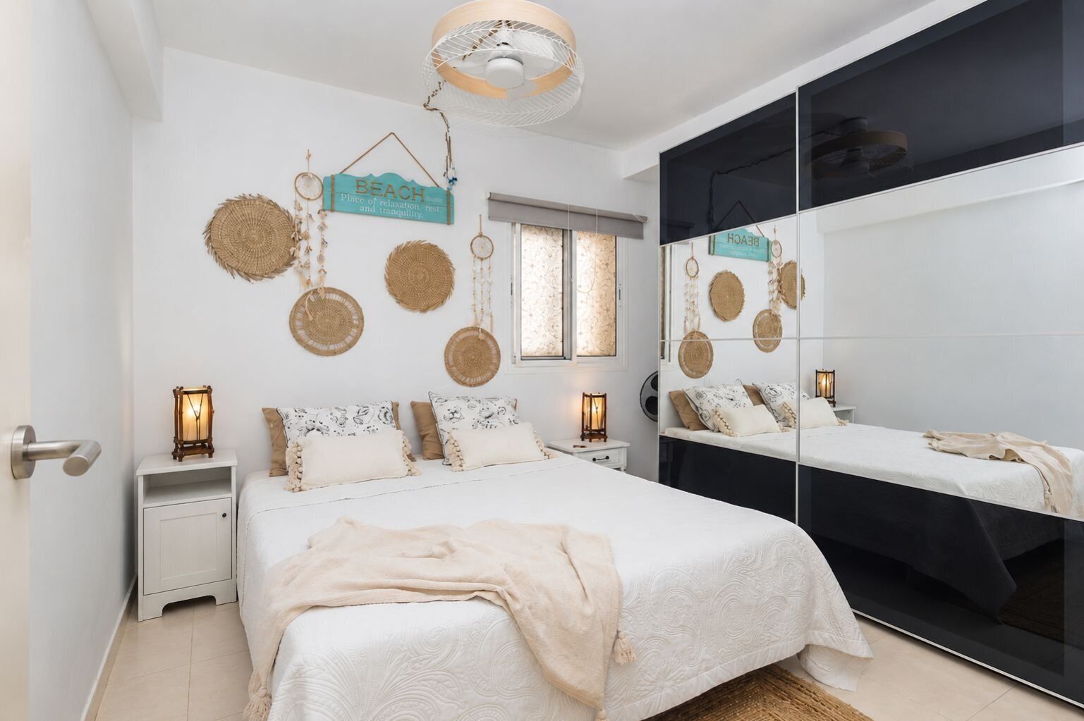 Une chambre à coucher comprenant un lit, des tables de chevet, des éléments de décoration murale et un grand miroir.
