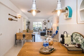A modern kitchen with a dining area, a coffee machine, and a view to the outside.