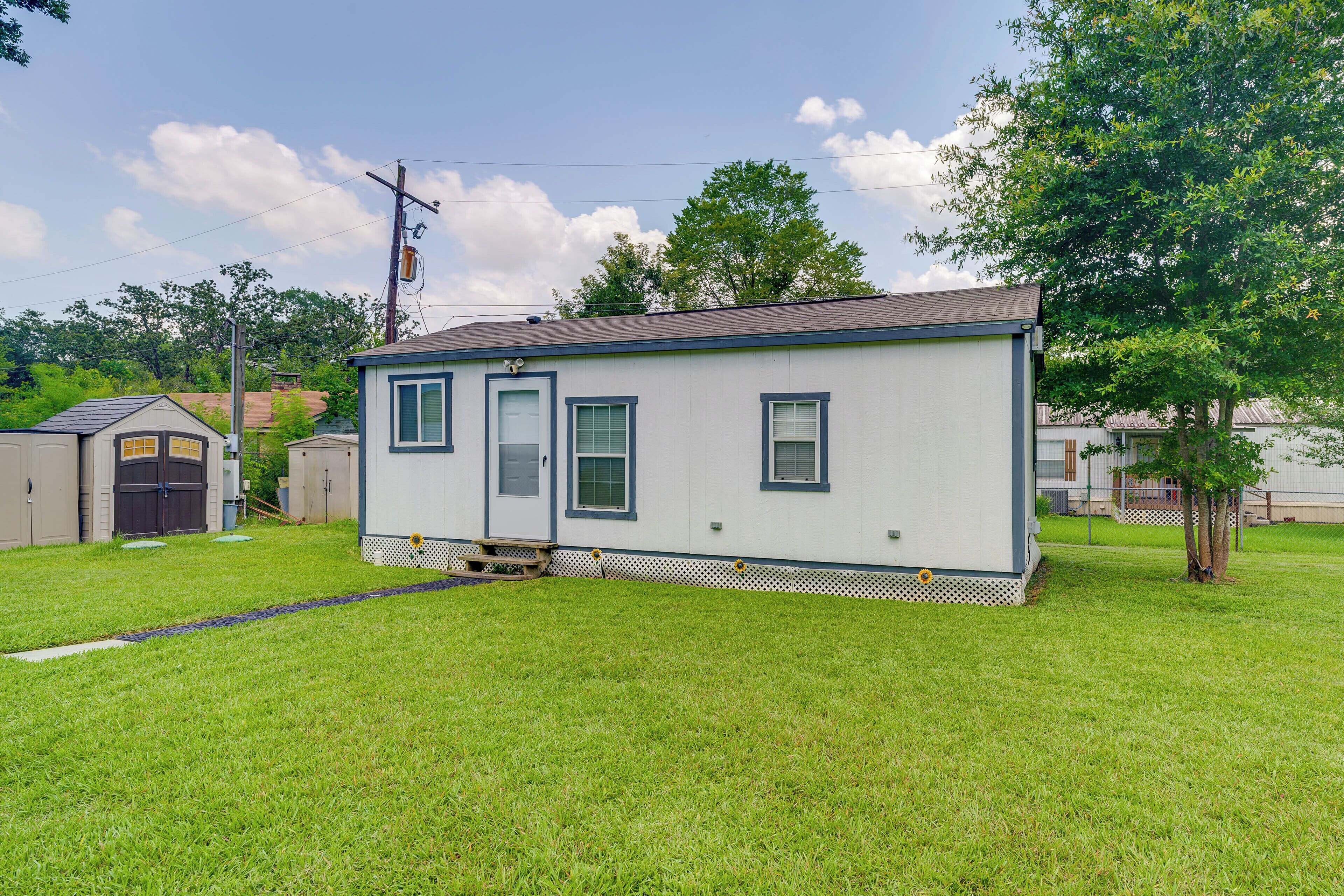 A single-story mobile home with a small porch, a garage, and a well-maintained lawn.