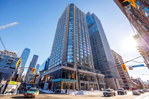 Un immeuble de grande hauteur doté d’une façade moderne en verre, situé à l’intersection de Yorkville Avenue.