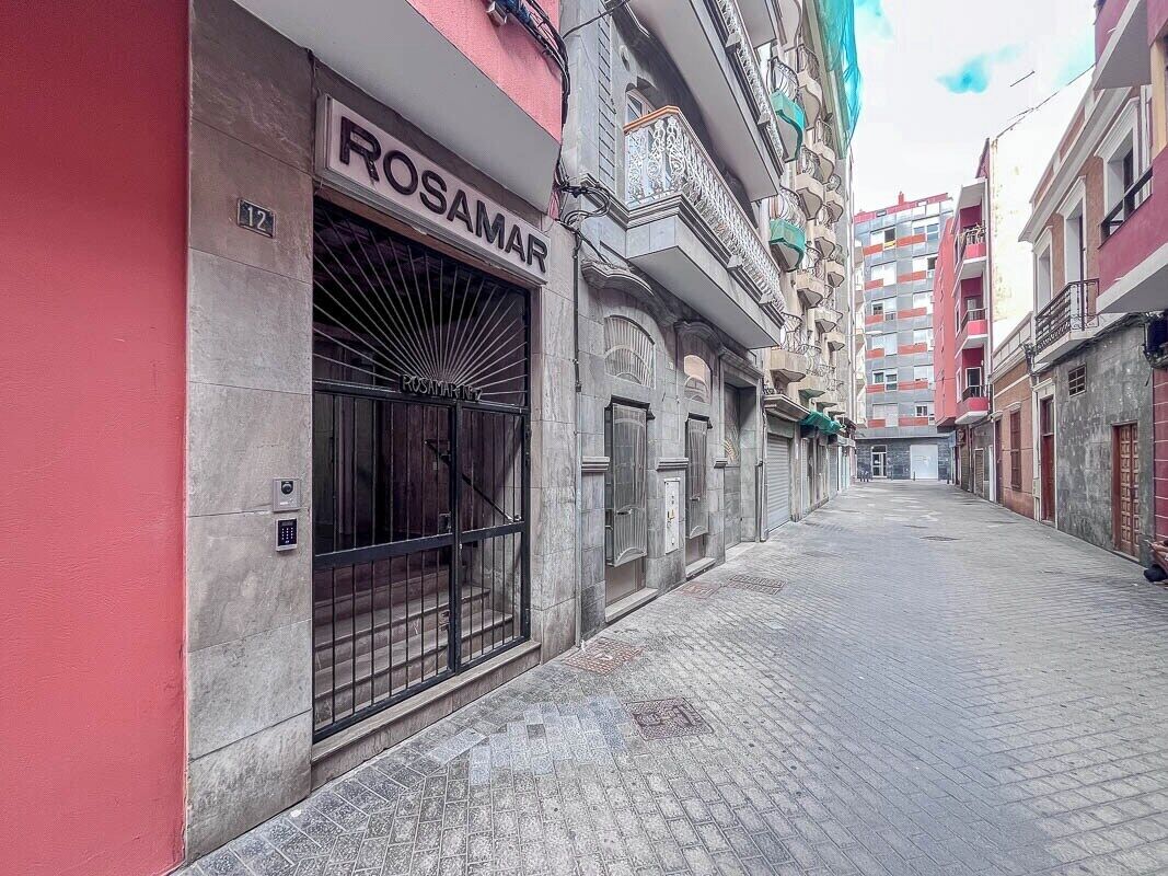 Una calle estrecha con un edificio que muestra el rótulo 'ROSAMAR' a la izquierda.