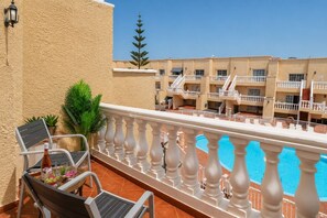A balcony with a pool, chairs, and a potted plant. - GuestReady - Bright Stay with Balcony (Caleta de Fuste)