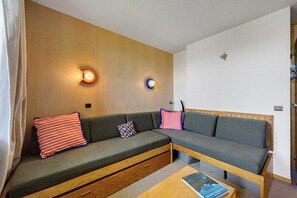 Ein gemütliches Zimmer mit einer Couch, zwei Wandleuchten und Holzboden.