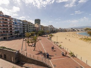 A beachside promenade with a brick walkway, palm trees, and a sandy beach. - GuestReady - 03A Livian Suites Int 2 pax 3A (Las Palmas de Gran Canaria)