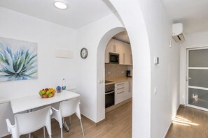 A modern kitchen with white cabinetry, a microwave, and a coffee maker. - GuestReady - Alemania Villa Garden (San Bartolomé de Tirajana)