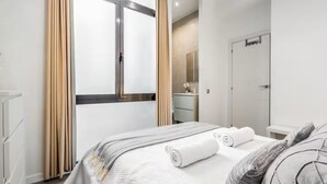 Una habitación de hotel moderna con cama, baño y vista a la ciudad.