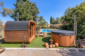 A wooden hot tub and a wooden structure with a hexagonal roof in a backyard with a pool. - GuestReady - Las Calas 1 Junior Suite Orquidea (Las Palmas de Gran Canaria)