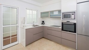 Eine kleine Küche mit Mikrowelle, Backofen und Kaffeemaschine.
