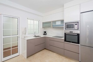 A compact kitchen with a microwave, oven, and a coffee maker. - GuestReady - Puerto Rico Family Retreat (Las Palmas de Gran Canaria)