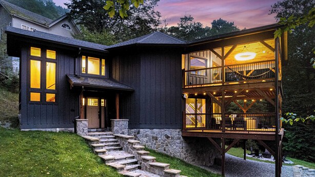 A two-story house with a stone staircase leading to a wooden deck. - Walk to Beech Slopes | Hot Tub, Sleeps 8 (Beech Mountain)
