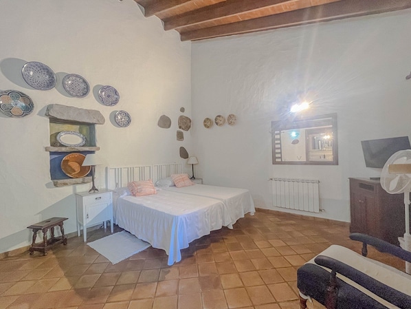 A bedroom with a bed, bedside tables, a mirror, and decorative plates on the wall. - GuestReady - Las Calas 4 Double Room Lirio (Vega de San Mateo)