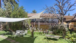 A garden with a patio, a white table, and chairs. - GuestReady - Las Calas 4 Double Room Lirio (Vega de San Mateo)