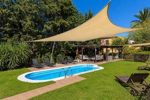 A swimming pool with a shaded area, lounge chairs, and a covered patio. - GuestReady - Las Calas 8 Double Room Gerbera (Las Palmas de Gran Canaria)