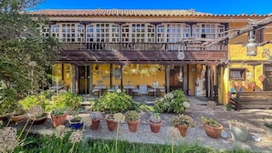 A building with a tiled roof, a balcony, and outdoor seating. - GuestReady - Las Calas 8 Double Room Gerbera (Las Palmas de Gran Canaria)