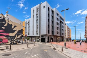 Um edifício moderno com fachada plana, várias janelas e entrada no nível da rua.