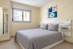 Quarto com cama, janela e quadros na parede.