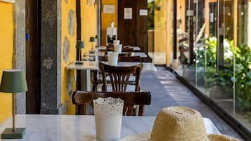 Filas de mesas y sillas en un restaurante con vista a zonas verdes.