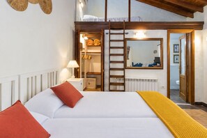 A bedroom with a bed, pillows, a bedside lamp, a wardrobe, a mirror, and a view of the bathroom. - GuestReady - Las Calas 3 Double Room Peonia (Las Palmas de Gran Canaria)