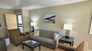 A living room with a sofa, two armchairs, a coffee table, and two lamps. - Machronicles Properties at Sand Pebbles Resort in beautiful Solana Beach (Solana Beach)