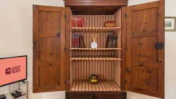 Un meuble en bois aux portes ouvertes, contenant des livres et un objet décoratif.