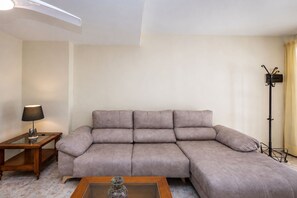 A living room with a sofa, a side table with a lamp, a floor lamp, and a coffee table. - GuestReady - Duplex Turman Agaete Terrace (Agaete)