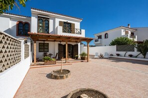 A courtyard with a covered seating area, a fire pit, and potted plants. - GuestReady - Duplex Turman Agaete Terrace (Agaete)