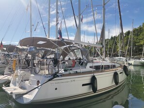 A sailboat named 'SUN ODYSSEY 379' docked at a marina with other boats, clear skies, and a calm water surface. - Sibenik Sun and Beach Sailing Extravaganza (Skradin)
