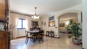 A dining area with a wooden table, chairs, a chandelier, and a potted plant. - Villa Sole D'Oro - pool, garden, and ocean view (Carrubazza-Motta)