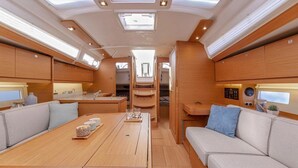 Interior moderno de una autocaravana con zona de comedor, asientos y cocina.