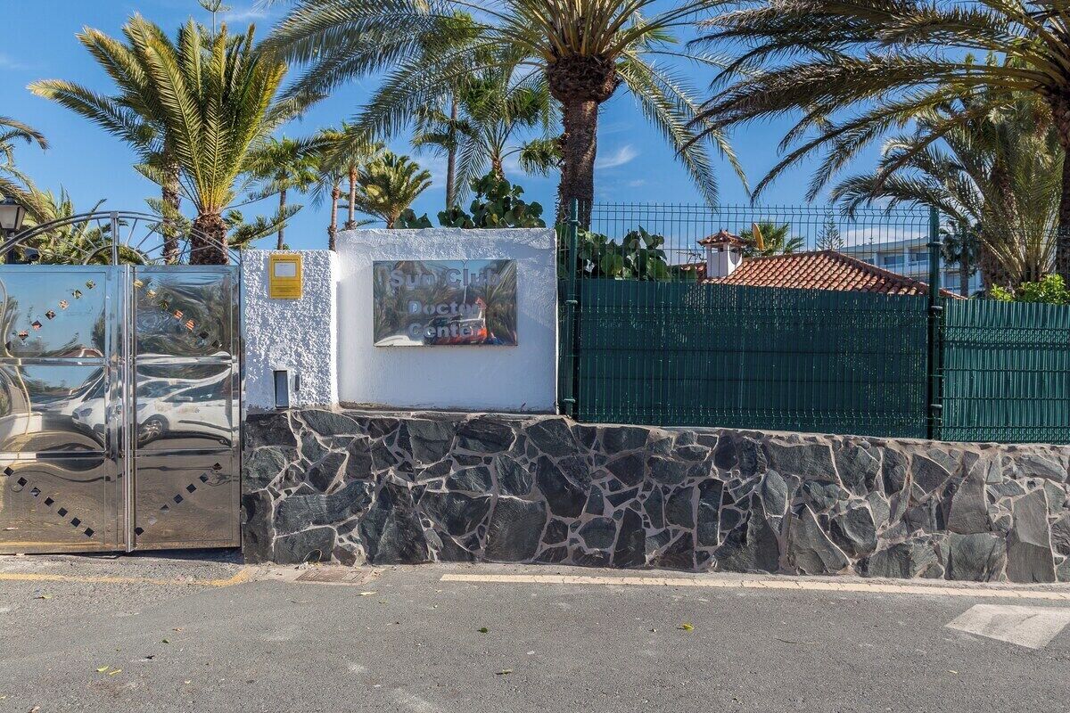 Un espace clos délimité par un mur de pierre, une porte en métal et un panneau indiquant un cabinet médical.