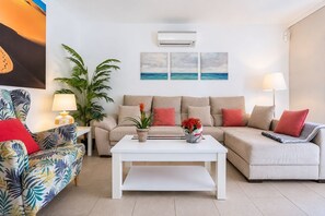 A living room with a sofa, a coffee table, a lamp, and a plant. - GuestReady - Sun Club Terrace and Pool (San Bartolomé de Tirajana)