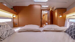 En kompakt autocamper-indretning med seng, to puder, trævægge og et skydetag.