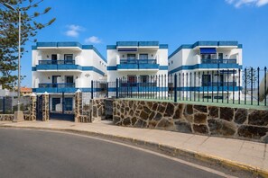 A three-story building with a stone wall and a metal fence. - GuestReady - Bello Horizonte Sea View and Pool (San Bartolomé de Tirajana)