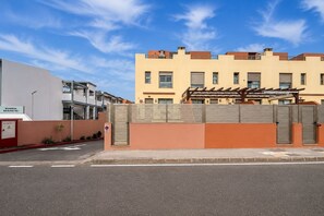 A residential building with a gated entrance and a parking area. - GuestReady - Villa with Pool and Terrace (Costa Teguise)