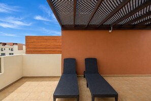 A rooftop terrace with two lounge chairs and a pergola structure. - GuestReady - Villa with Pool and Terrace (Costa Teguise)