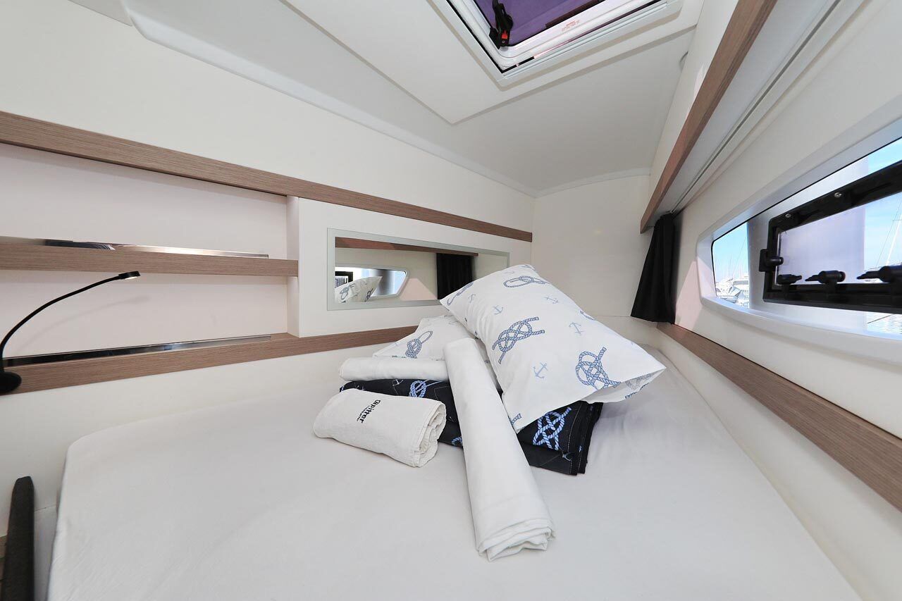 Ein modernes Hotelzimmer mit Bett, Fenster mit Blick, Nachttisch und Spiegel.