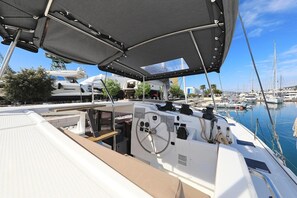 Un port de plaisance avec des bateaux amarrés, un espace abrité avec un volant, et une vue sur le port en arrière-plan.