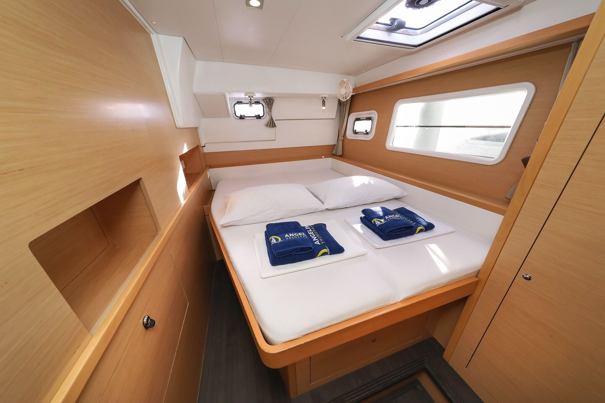 A compact cabin with a bed, two windows, and a small storage area.