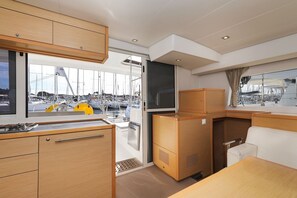 Eine kleine Kombüze mit Blick auf den Hafen, inklusive Spüle und Stauraum.