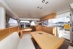 A yacht interior with a dining area, kitchen, and seating. - Sun-Kissed Sailing Adventure in Zadar, Croatia (Biograd na moru)