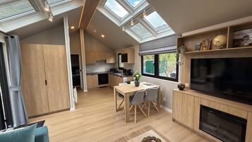 A modern kitchen with skylights, a dining area with a TV, and a cozy seating area.