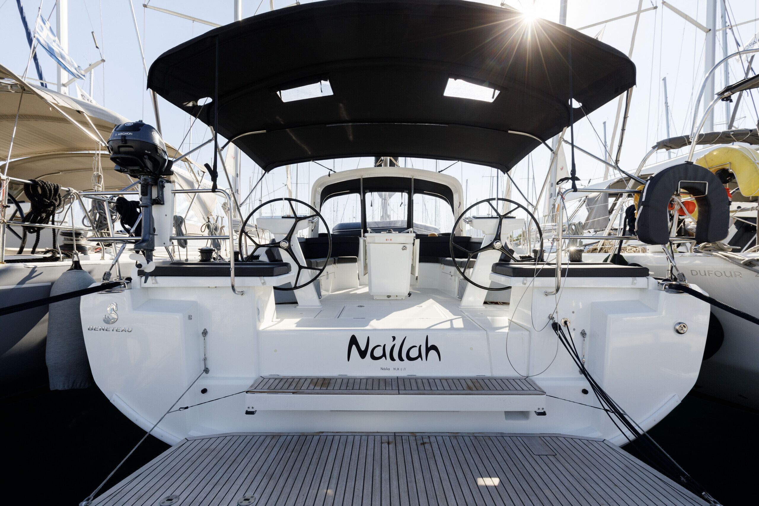Das Deck eines Segelbootes mit dem Namen 'Nailah' und einem Steuerrad.