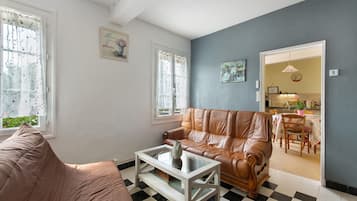A living room with a brown leather sofa, a white coffee table, and a checkered floor.