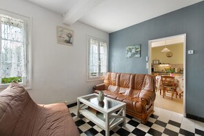 A living room with a brown leather sofa, a white coffee table, and a checkered floor.